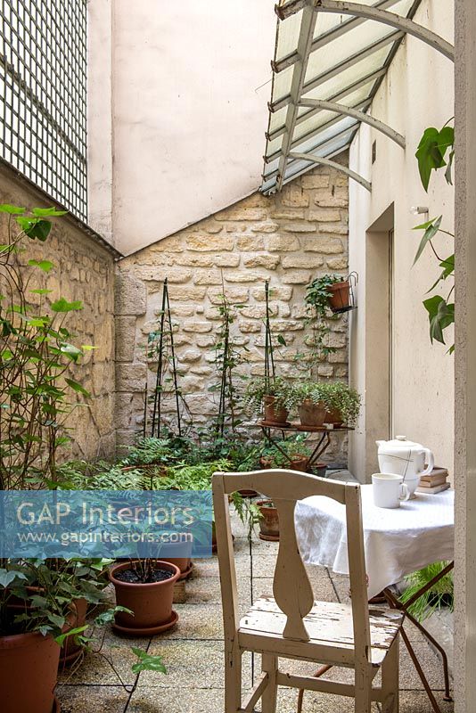 Small courtyard garden with cafe table and chair 