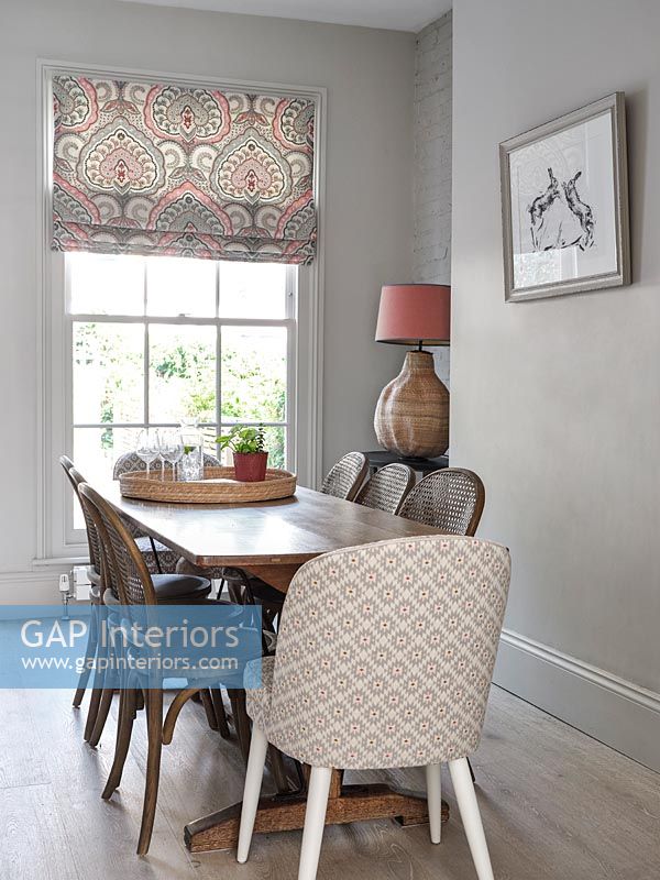 Patterned chair at head of modern wooden dining table 