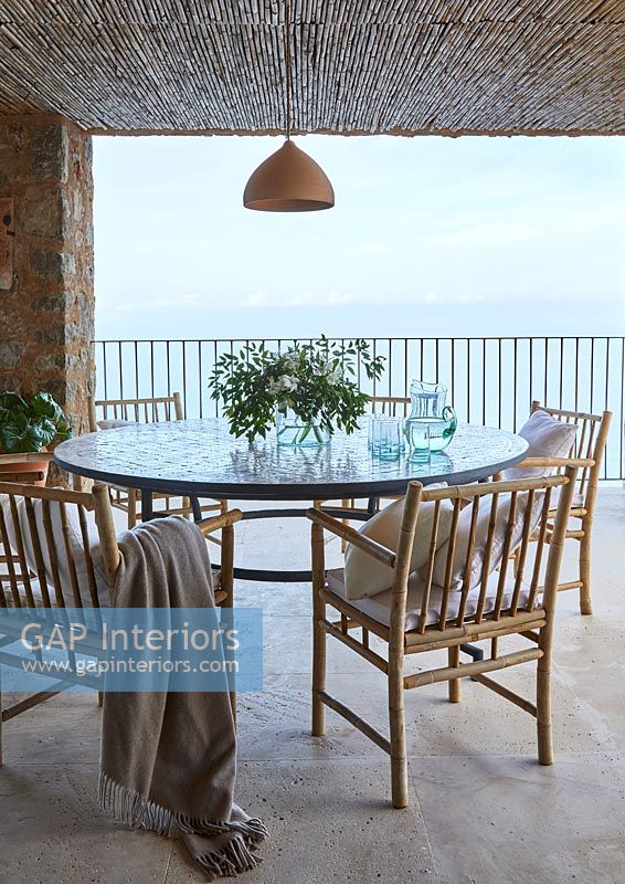 Round table and chairs on balcony with sea views 