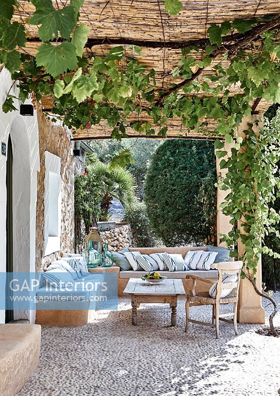 Furniture under pergola on terrace of country house in summer 