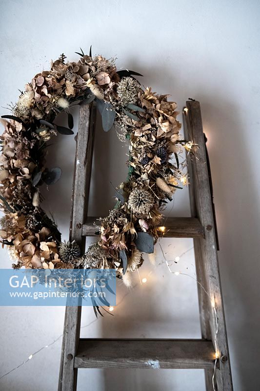 Decorative wreath of dried flowers and feathers with fairy lights 