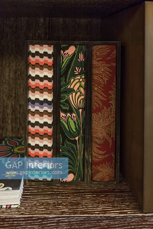 Decoratively covered books on shelves - detail 