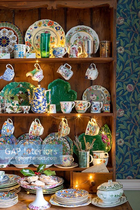 Display of colourful plates and crockery on wooden dresser 