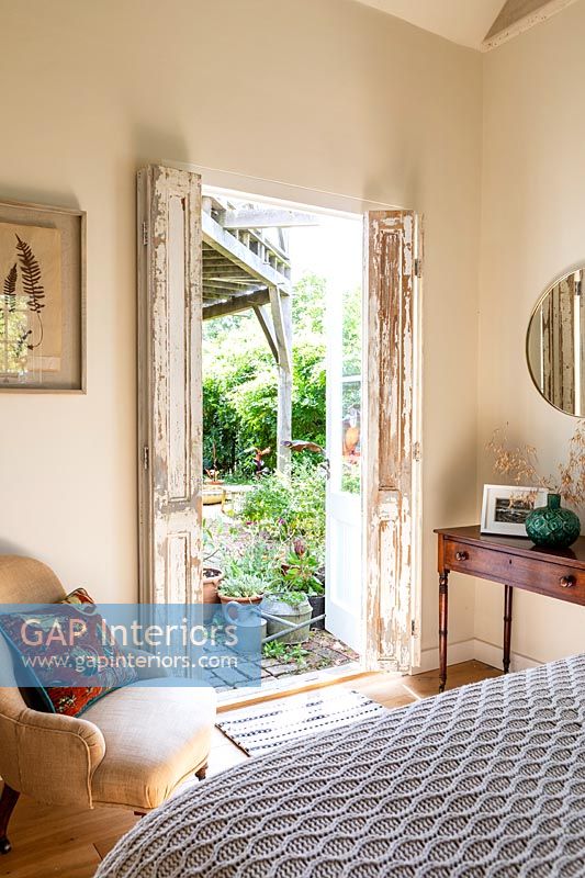 French doors open to garden in country bedroom 