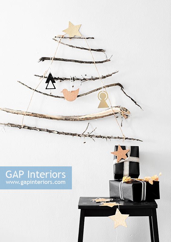 Black and white gifts on table under wall mounted twig tree 