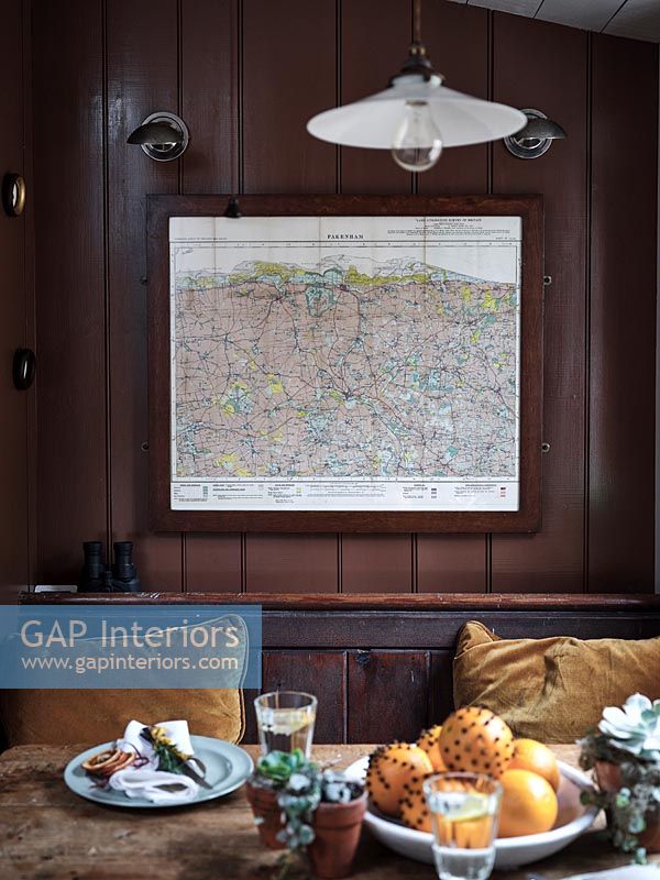 Map on wall of country dining room - Christmas orange pomanders on table 
