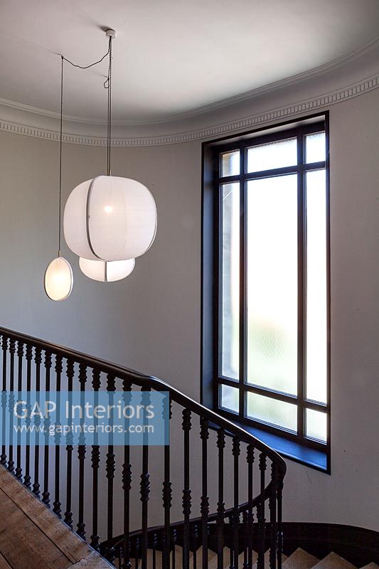 White pendant lighting above black and white painted staircase 