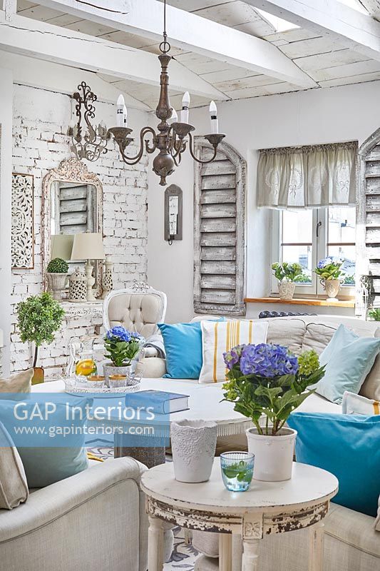 Blue accessories in white shabby chic style living room 