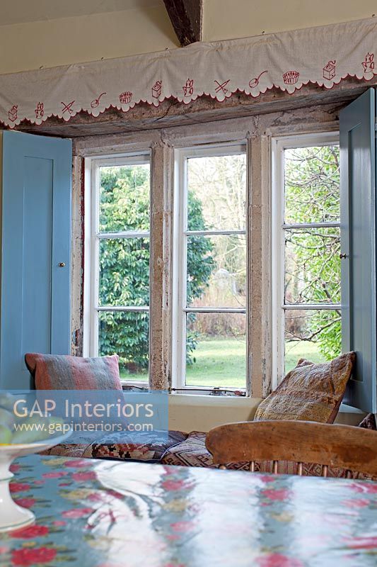 Country dining room with window seat overlooking garden 