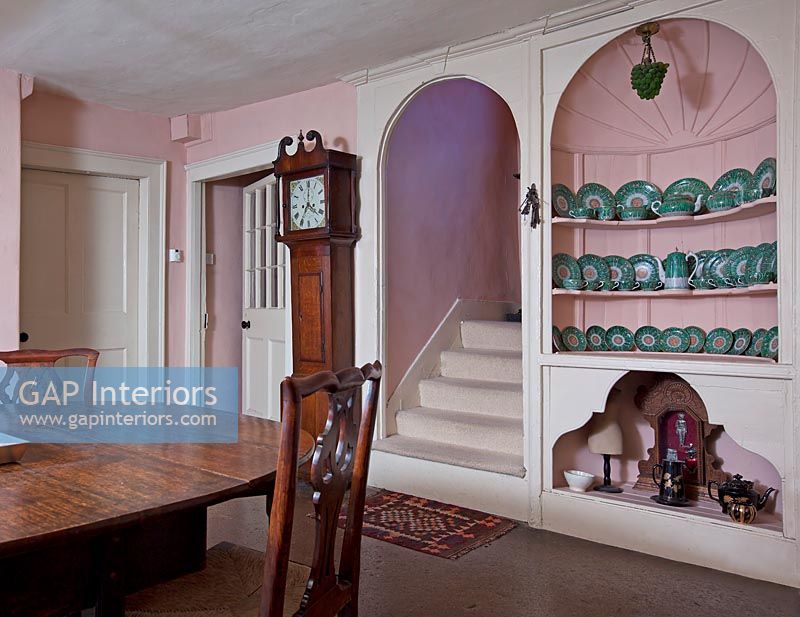 Decorative built-ins shelving and arched doorway in country dining room 