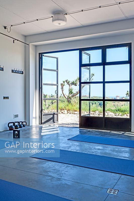Modern yoga studio with scenic views through open patio doors 