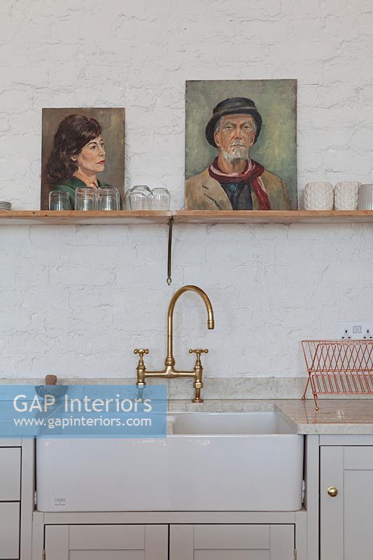 Painted portraits on shelf above butler sink 