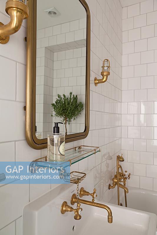Gold taps and accessories in white bathroom 