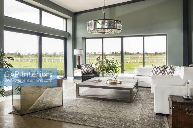 Modern living room with mirrored chair and views to countryside
