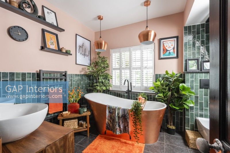 Colourful bathroom with free standing copper covered bathtub