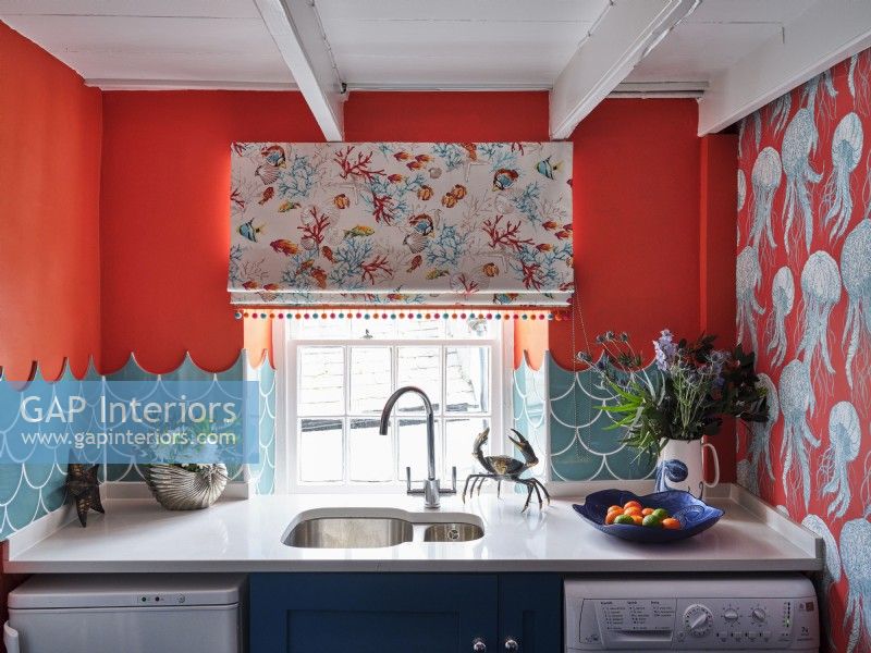 Sea inspired ornaments, tiles, blinds and wallpaper in a colourful kitchen
