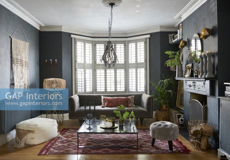 Eclectic living room in a victorian house with a vintage , modern and boho mix of furniture. 