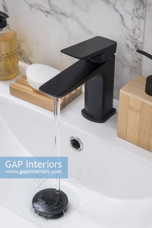 Detail of modern black tap and sink