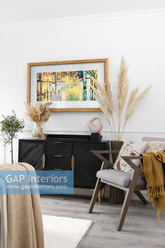 Wall mounted television with art image above a sideboard in a modern living room