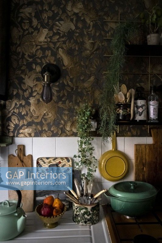 Embossed gold and black wallpaper on kitchen wall above worktop