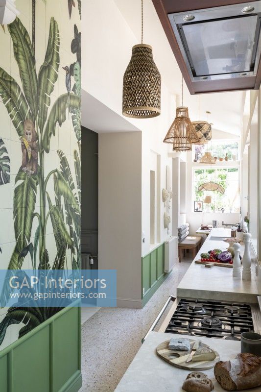 Tropical wallpaper and green panels in modern galley kitchen