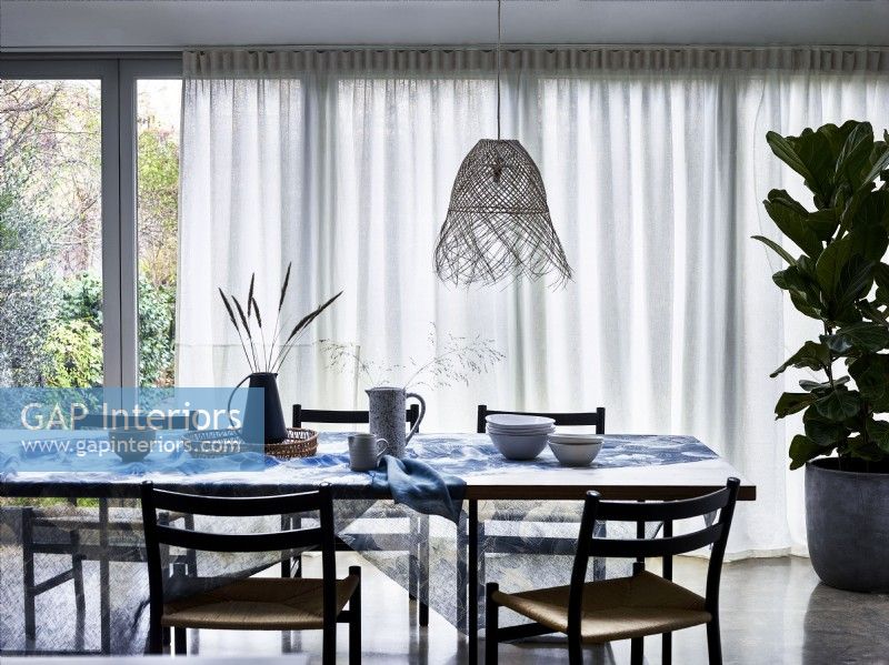 Dining table with white voile diffuser curtains