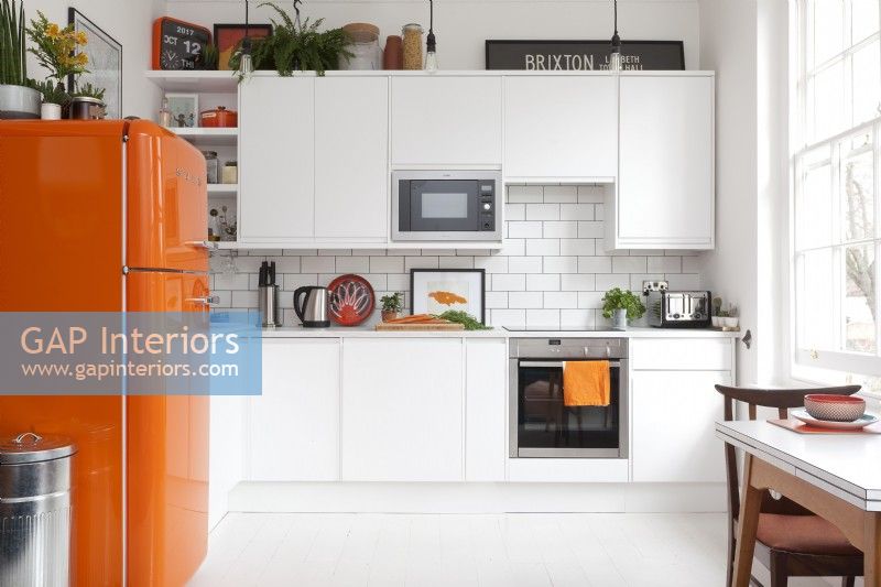 Contemporary White Kitchen with orange accents