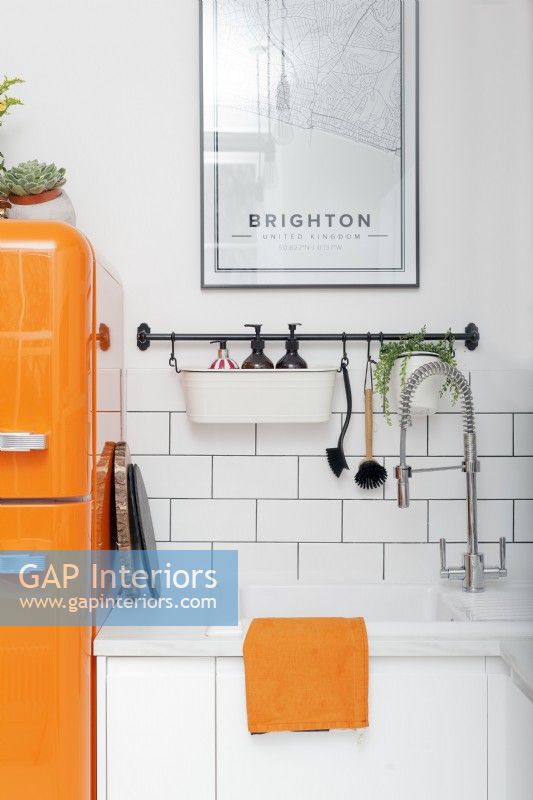 Sink detail white kitchen with orange accents

