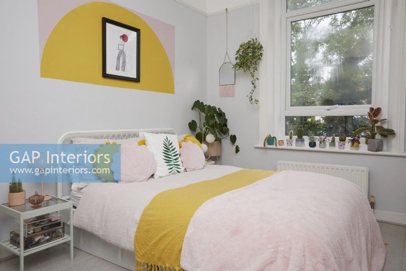 Bedroom with colour block shapes painted on the wall.