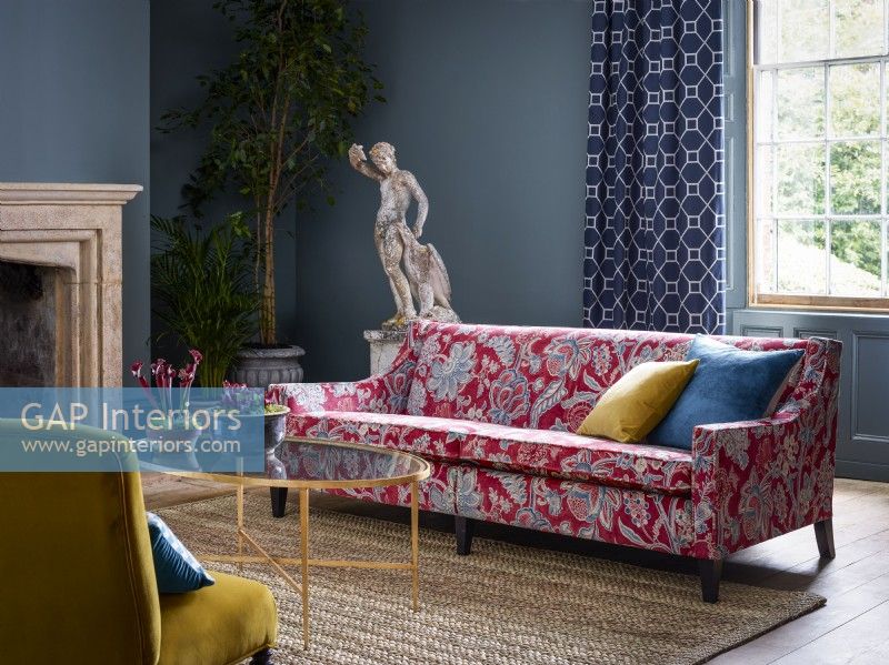 Classic living room with red patterned sofa and blue walls
