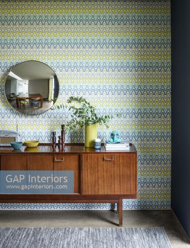 Yellow patterned wallpaper with mid century sideboard