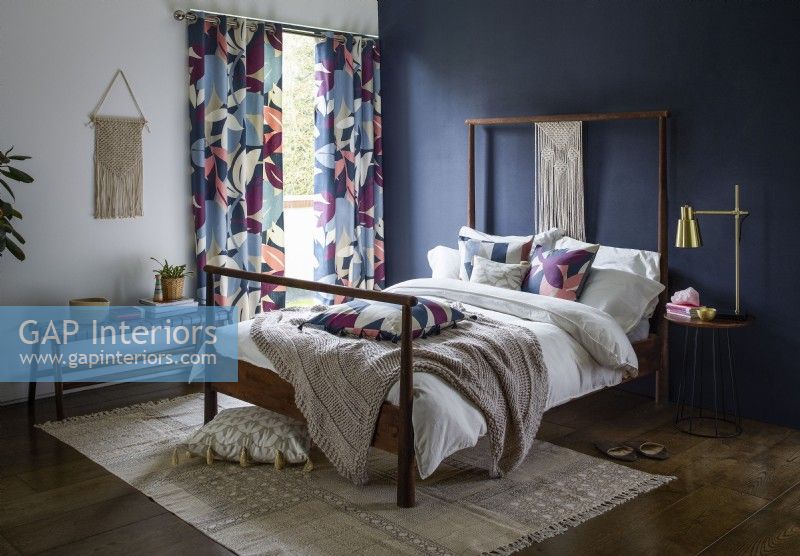 Bedroom with blue painted wall and patterned curtains