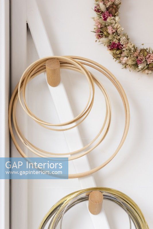 Detail of dried flower hoops hanging on wooden pegs