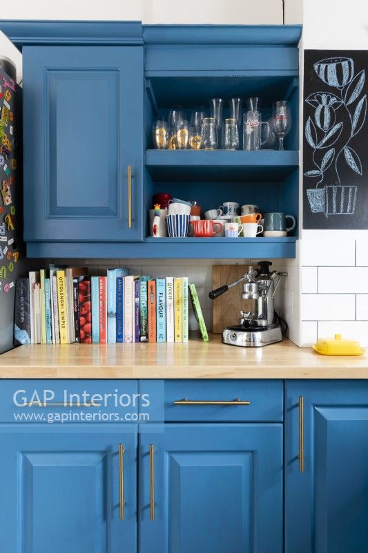 Repainted blue kitchen cabinets and wall mounted cupboard with open shelf