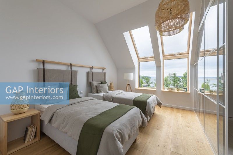 Large attic bedroom with two beds and views of nature
