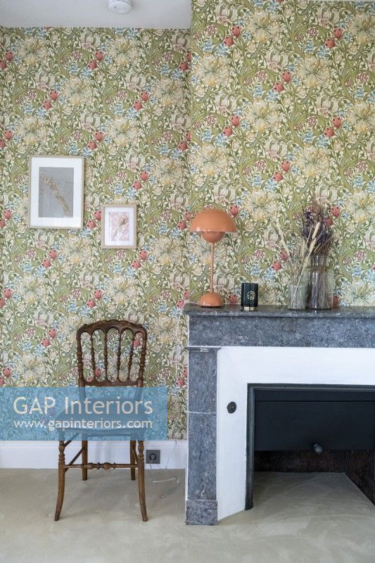 Fireplace in country bedroom with floral wallpaper
