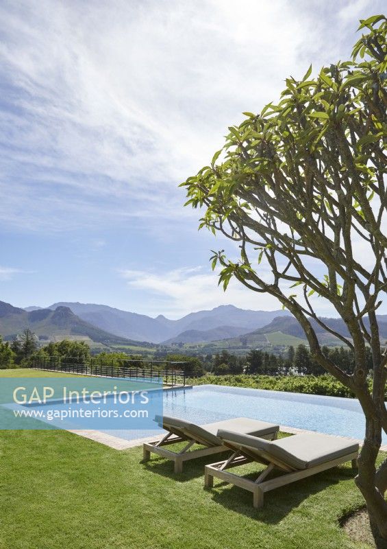 Swimming pool and gardens with mountain range in background