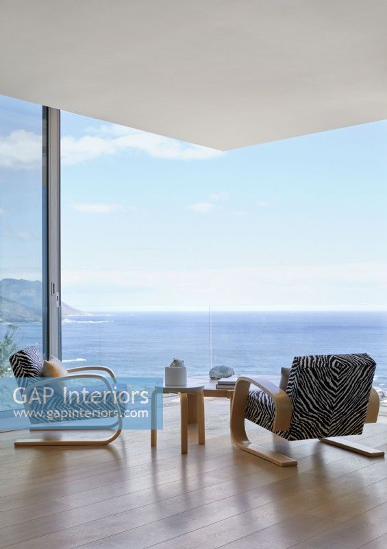 Animal print armchairs facing sea view in contemporary living room