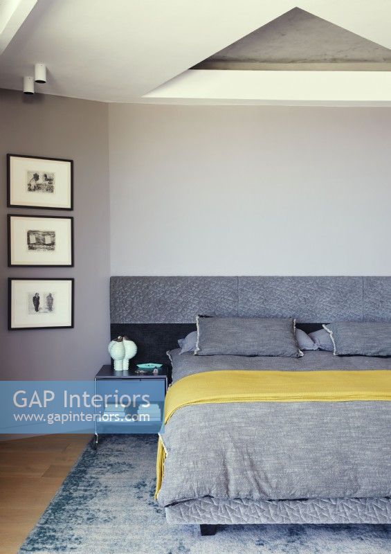 Grey and yellow bedding on bed in modern bedroom