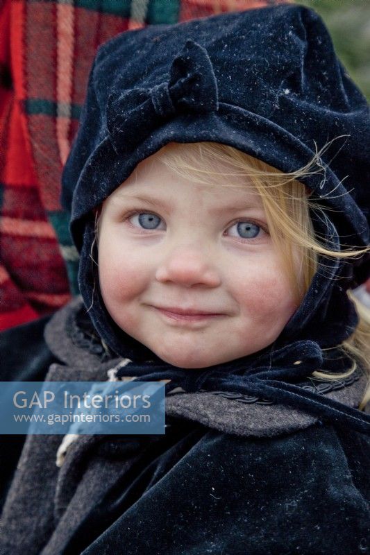 Little girl dressed with winter hat and coat for a sleigh ride at Christmas