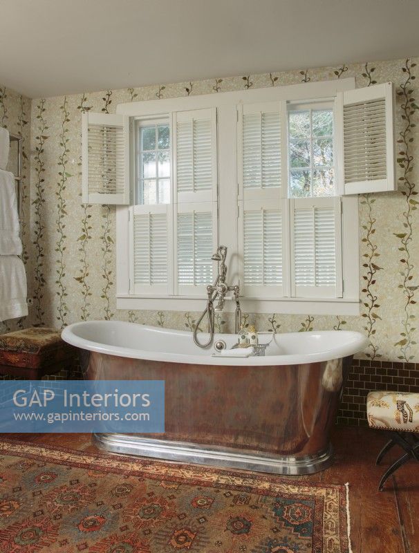 To satisfy a serious yearning for a glorious master bath, Ellen carved space from an adjacent bedroom to fit and feature this deep, old English-style soaking tub fashioned in polished tin and porcelain. 