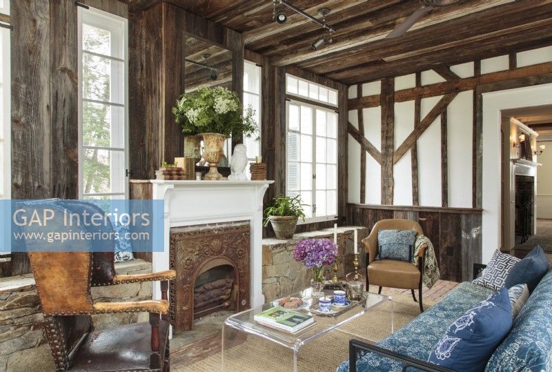 Ellen Allenâ€™s living room welcomes visitors with a vivid contrast in texturesâ€”refurbished post-and-beam barn boards, exposed brick and flagstone, a whitewashed antique hearth, and a casual sisal rug. The blue Kantha quilt draped over a classic 1950s sofa was hand-printed in India.