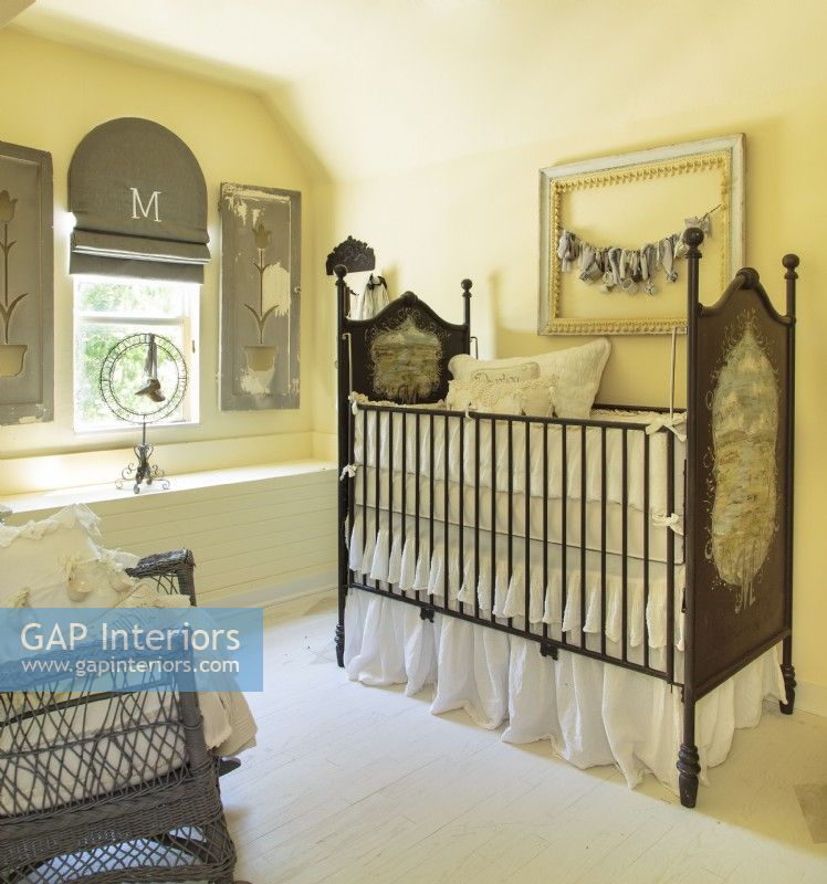 Kathy painted the nursery a rich buttercream for a warm color shift from other rooms, making it feel separate somehow, like a destination.  An old wicker rocker and pillows made of vintage linens are timeless classics. 