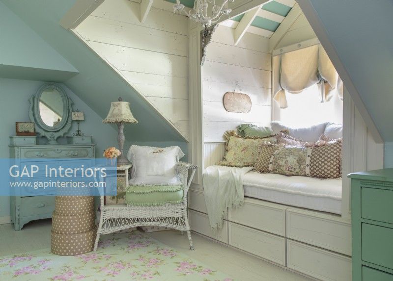 In a corner of the guest bedroom, deep dormers make way for extra seating and storage. Theyâ€™re topped with rafters for a loft look. Because odd wall angles can look choppy, Kathy painted the niche a serene blue. 