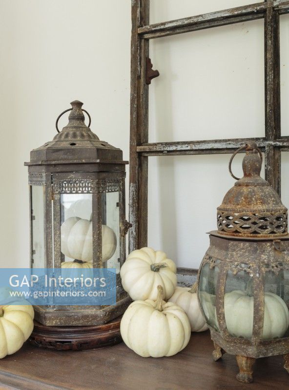 In keeping with Kayla's fall theme, gourds nestles in and around rustic lanterns on the dining room sideboard.