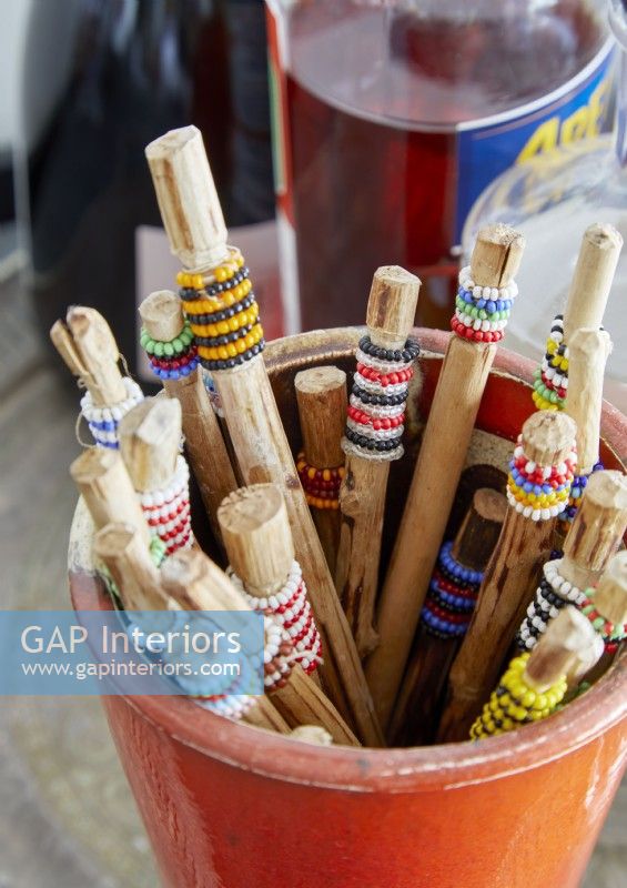 Bucket of sticks with colourful beads around them