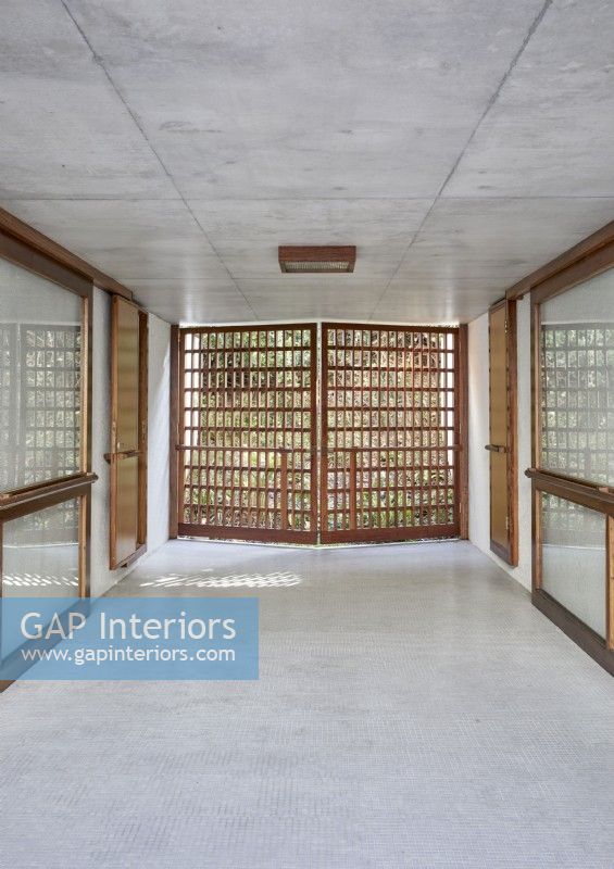 Slatted wooden doors in contemporary concrete hallway