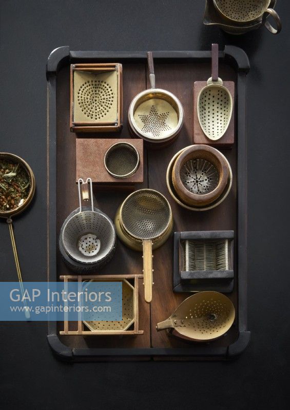 Detail of a black tray with display of tea strainers 