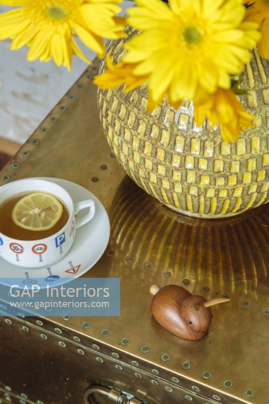 A vintage yellow vase filled with flowers in the same color family adds a cheerful note.