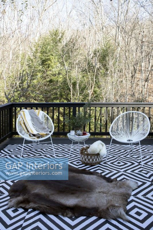 Outdoor seating on wooden deck in the countryside.